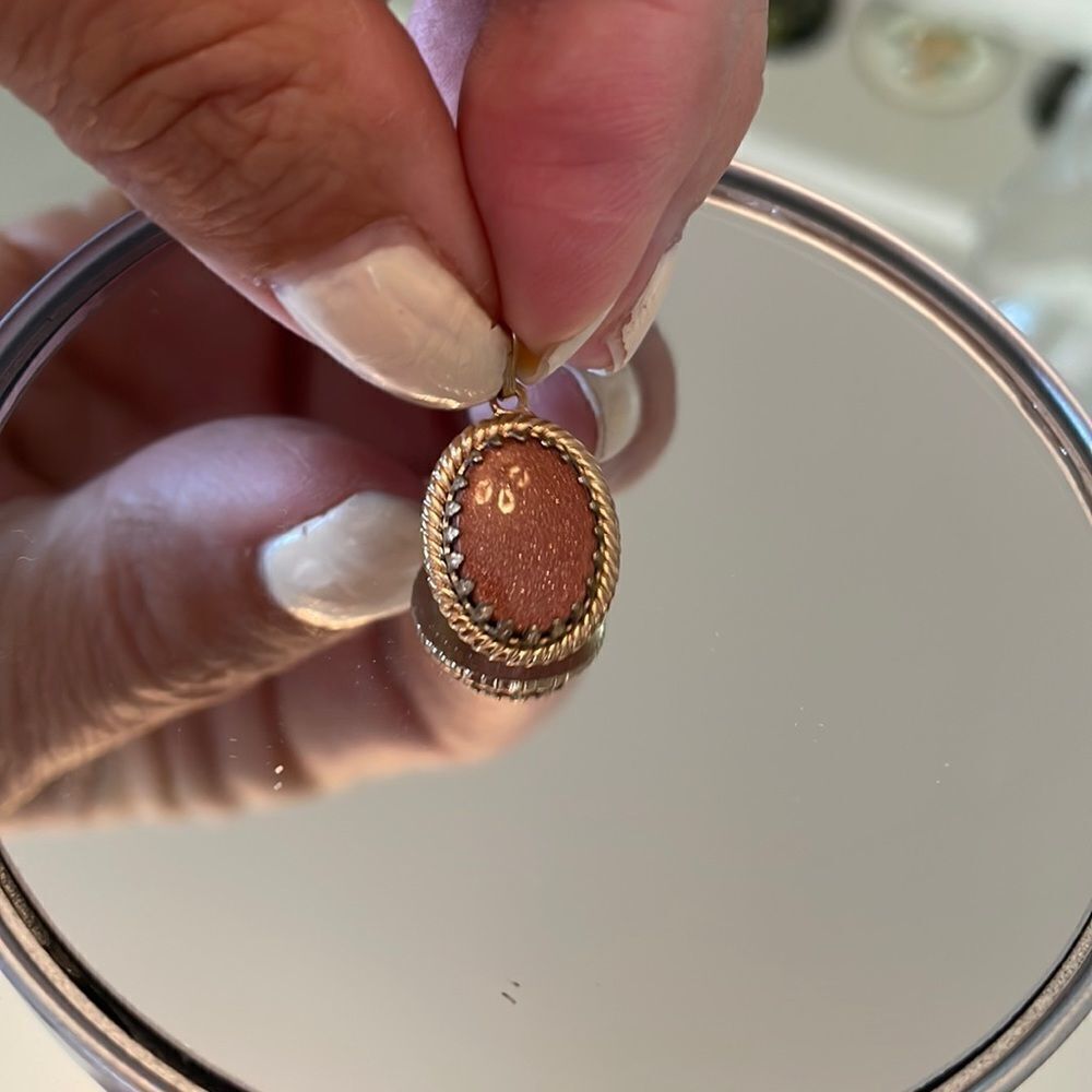 Vintage oval pendant with sparkly orange stone